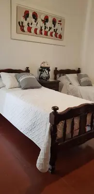 a bedroom with two beds and a picture on the wall at Casalago in Villa Carlos Paz