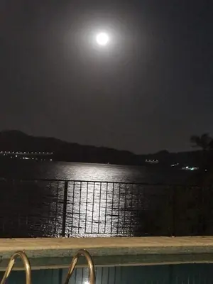a full moon over a body of water at night at Casalago in Villa Carlos Paz