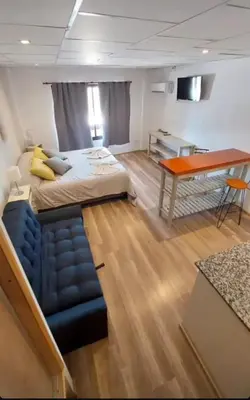 a bedroom with a bed and a desk and a couch at Aparts Aldea Del Montañes in Mina Clavero