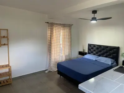 a bedroom with a blue bed and a window at Departamentos M&M in Villa Cura Brochero
