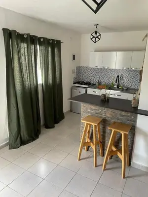 a kitchen with a counter and two stools in a room at Departamentos M&M in Villa Cura Brochero