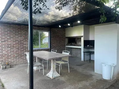 a patio with a table and chairs and a brick wall at Departamentos M&M in Villa Cura Brochero