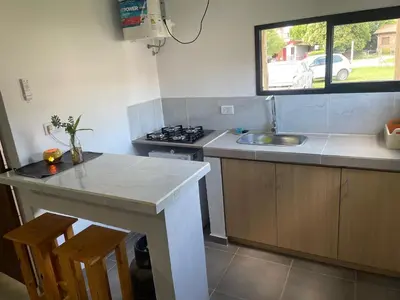 a kitchen with a counter and a sink and a stove at Departamentos M&M in Villa Cura Brochero