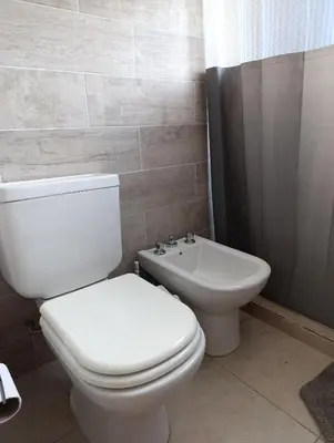 a bathroom with a white toilet and a sink at La casona de Yatel in Santa Rosa de Calamuchita
