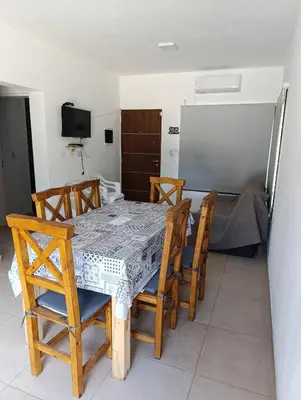 a dining room with a table and chairs and a refrigerator at La casona de Yatel in Santa Rosa de Calamuchita