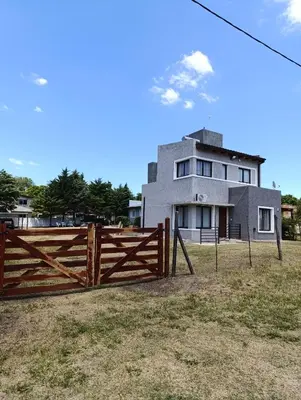 a house with a wooden fence in front of it at La casona de Yatel in Santa Rosa de Calamuchita