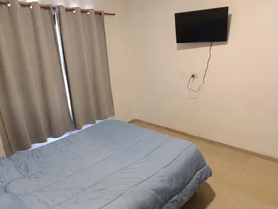 a bedroom with a bed and a flat screen tv at La casona de Yatel in Santa Rosa de Calamuchita