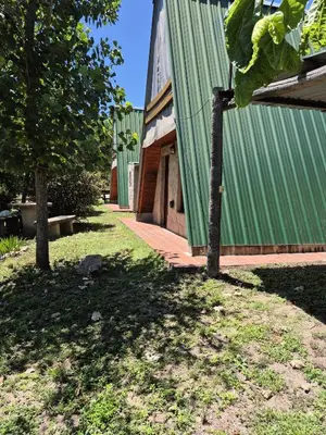 a building with a green roof and a tree at Alpina 3 segunda usina in Dique Nivelador