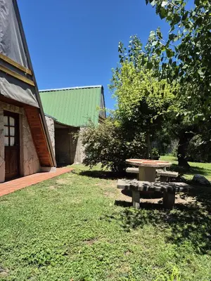 a picnic table in a yard next to a building at Alpina 3 segunda usina in Dique Nivelador