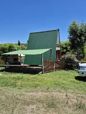 a house with a green roof and a fence at Alpina 3 segunda usina in Dique Nivelador