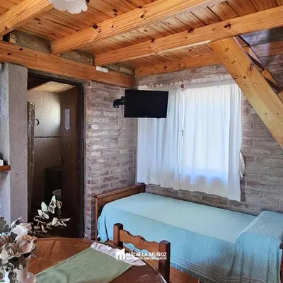 a bedroom with a bed and a tv on a brick wall at Alpina 3 segunda usina in Dique Nivelador