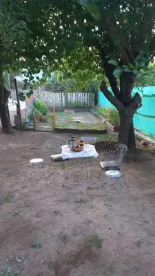 a picnic table and chairs under a tree at Happy House in Tanti