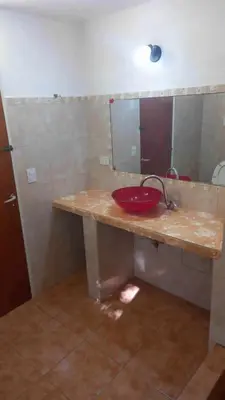 a bathroom with a red sink and a mirror at Happy House in Tanti