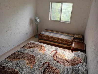 a room with two beds in a room with a window at Happy House in Tanti