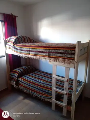 a bunk bed with a bench in a room at Departamento centro Carlos Paz in Villa Carlos Paz