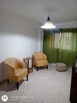 a living room with two chairs and a green curtain at Departamento centro Carlos Paz in Villa Carlos Paz