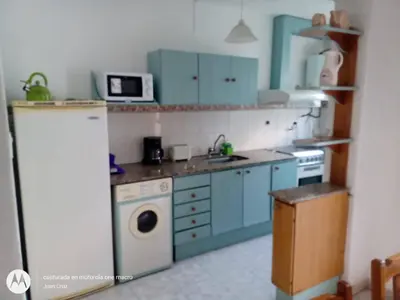 a kitchen with blue cabinets and a white refrigerator at Departamento centro Carlos Paz in Villa Carlos Paz