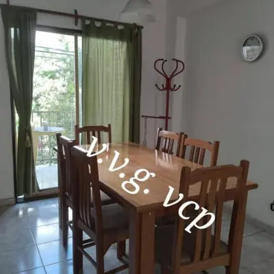a wooden dining room table with chairs and a table at Departamento centro Carlos Paz in Villa Carlos Paz