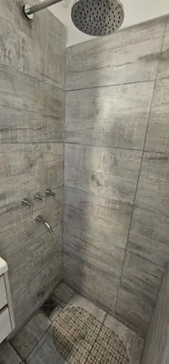 a bathroom with a shower with a stone wall at Monoambiente Centro in Cordoba