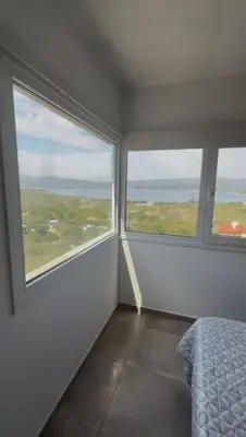 a bedroom with two large windows and a bed at Chalet de montaña in Villa Carlos Paz