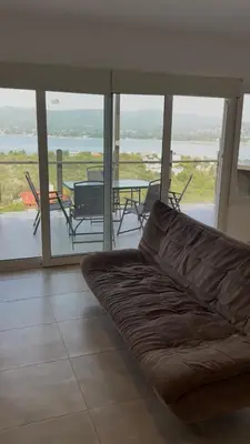 a couch in a living room with a view of a patio at Chalet de montaña in Villa Carlos Paz