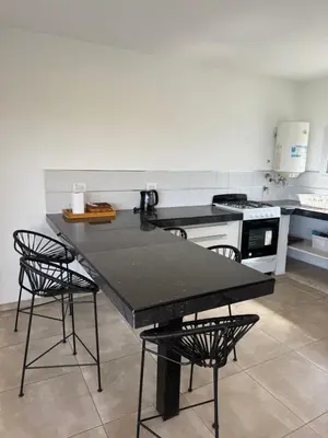 a kitchen with a black table and chairs at Chalet de montaña in Villa Carlos Paz