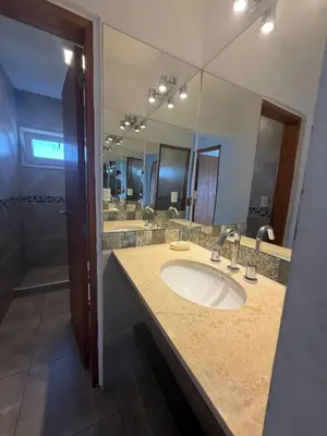 a bathroom with a sink and a large mirror at Chalet de montaña in Villa Carlos Paz