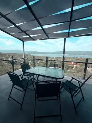 a table and chairs on a patio with a view at Chalet de montaña in Villa Carlos Paz