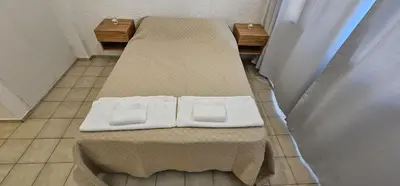 two beds in a hospital room with towels on them at Monoambiente Centro in Cordoba