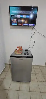 a television on a wall with a table with a remote control at Monoambiente Centro in Cordoba