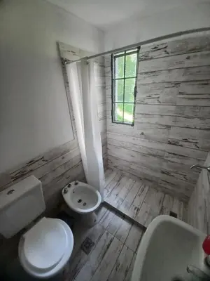 a bathroom with a toilet and a sink and a window at Amaneceres de Cabalango in Cavalango