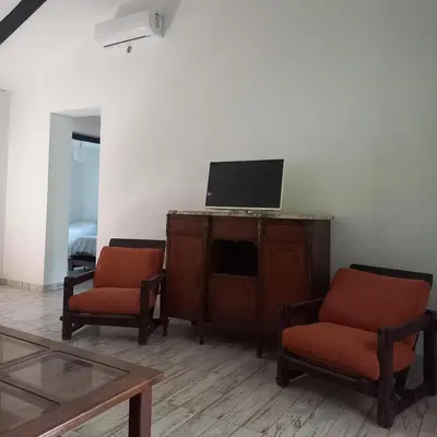 a living room with two chairs and a tv on a cabinet at Amaneceres de Cabalango in Cavalango