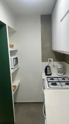 a white kitchen with a stove and a microwave at Duarte Quiros Apartamento in Cordoba