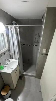 a small bathroom with a shower and a sink at Duarte Quiros Apartamento in Cordoba