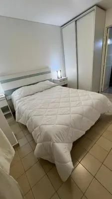 a bedroom with a bed with a white comforter at Duarte Quiros Apartamento in Cordoba