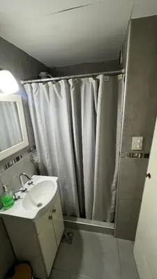 a bathroom with a shower curtain and a sink at Duarte Quiros Apartamento in Cordoba