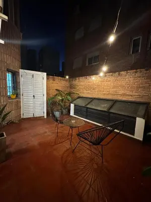 two chairs and a table on a patio at night at Duarte Quiros Apartamento in Cordoba