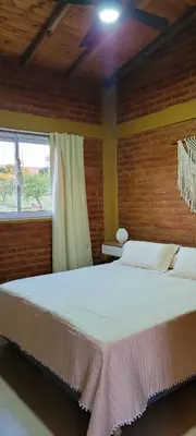 a bedroom with a large white bed in a room at Pedrolandia in Mina Clavero