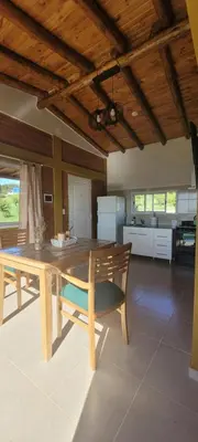 a kitchen with a wooden table and a wooden ceiling at Pedrolandia in Mina Clavero