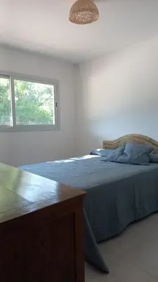 a bed in a white room with a window at La casa del león in San Antonio de Arredondo