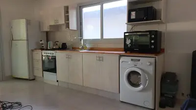 a kitchen with a washing machine and a microwave at La casa del león in San Antonio de Arredondo