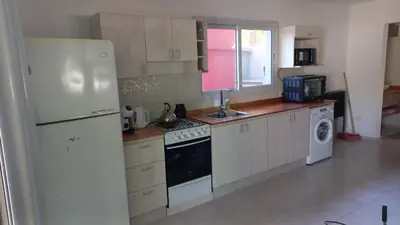 a kitchen with white appliances and a white refrigerator at La casa del león in San Antonio de Arredondo