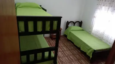 two bunk beds in a room with green sheets at Abu Ma! in Tanti
