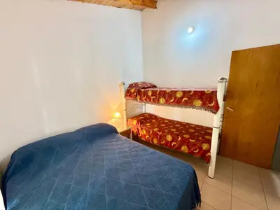 a small bedroom with a bed and a bunk bed at Mina Clavero Chalet in Mina Clavero