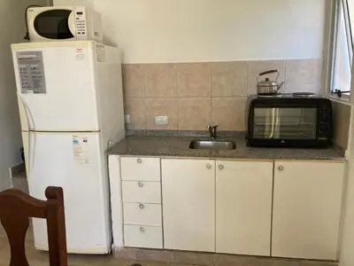 a kitchen with a white refrigerator and a microwave at Complejo Don otto in Cavalango