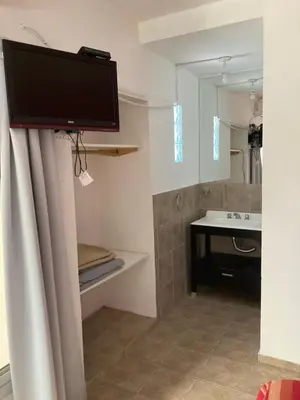 a bathroom with a sink and a tv on the wall at Complejo Don otto in Cavalango