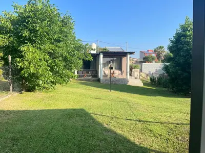 a yard with a house with a grass field at Complejo Don otto in Cavalango