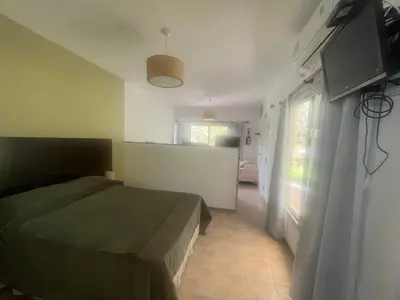 a bedroom with a bed and a room with a window at Complejo Don otto in Cavalango