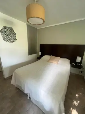 a bedroom with a large white bed and a lamp at Complejo Don otto in Cavalango