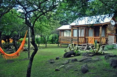 a log cabin with an orange hammock in front of it at Enkel Cabañas in José de la Quintana